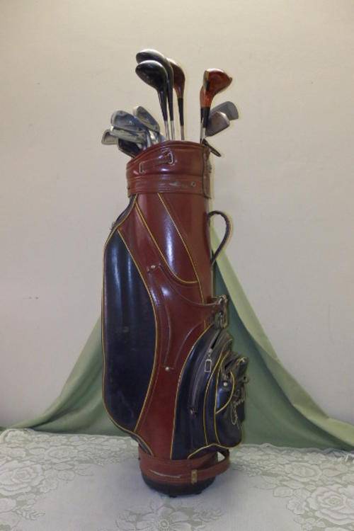 AN AWESOME VINTAGE GOLF CLUB SET INCLUDING WOODS AND IRONS IN A VINTAGE VINYL JOE POWELL BAG