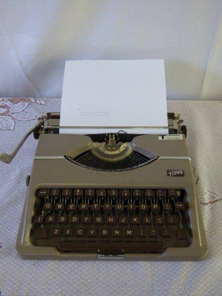 AN AMAZING ANTIQUE(1955) GOSSEN TIPPA, TYPEWELL PORTABLE TYPEWRITER IN ITS ORIGINAL HARD CARRY CASE.