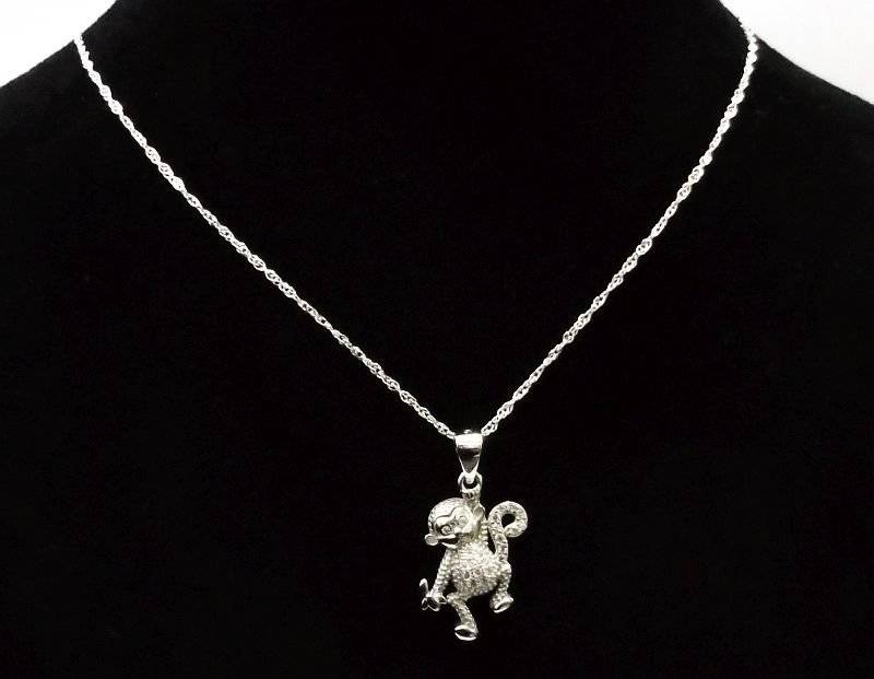 A CUTE STERLING SILVER MONKEY WITH BANANA PENDANT PLUS A 45 CM STERLING SILVER NECKLACE