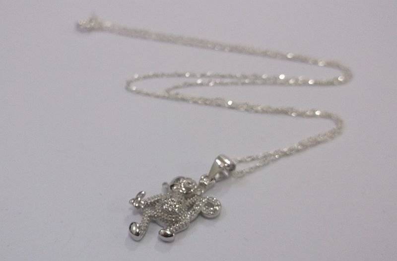 A CUTE STERLING SILVER MONKEY WITH BANANA PENDANT PLUS A 45 CM STERLING SILVER NECKLACE