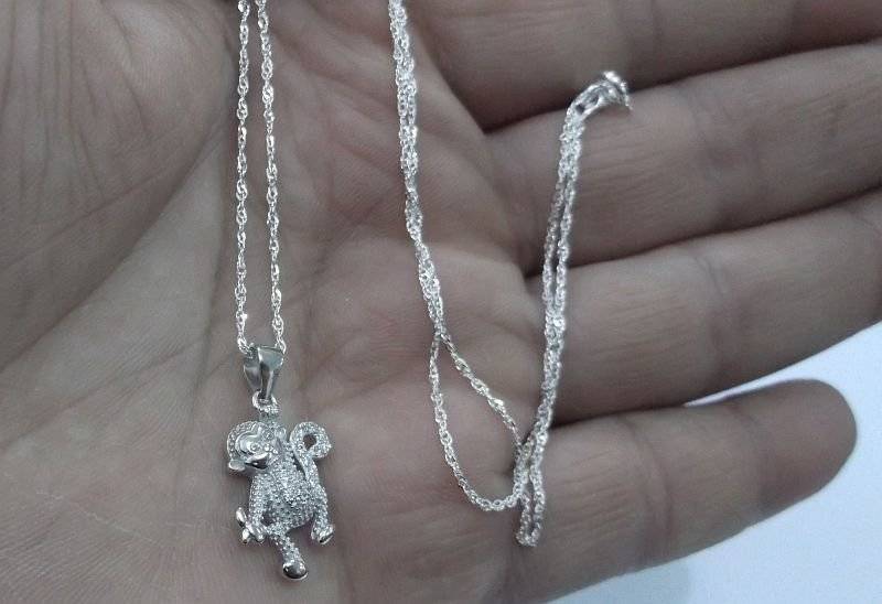 A CUTE STERLING SILVER MONKEY WITH BANANA PENDANT PLUS A 45 CM STERLING SILVER NECKLACE