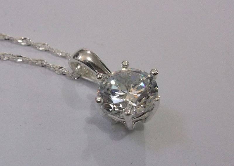 AN ELEGANT STERLING SILVER PENDANT WITH FACETED CLEAR STONE PLUS A 45 CM STERLING SILVER NECKLACE