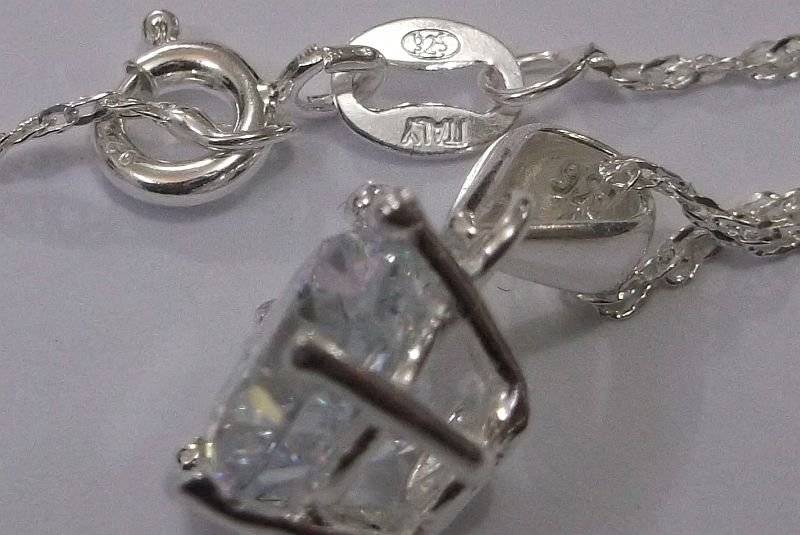 AN ELEGANT STERLING SILVER PENDANT WITH FACETED CLEAR STONE PLUS A 45 CM STERLING SILVER NECKLACE