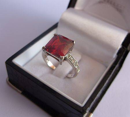 A MARVELOUS SOLID STERLING SILVER RING SET WITH A FACETED RED STONE & CZ STONES