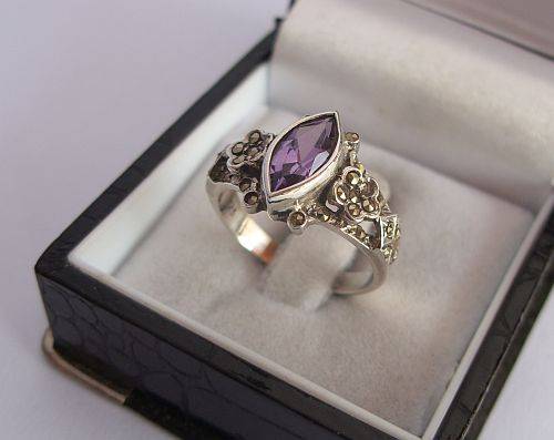 A CHARMING STERLING SILVER RING SET WITH A FACETED PURPLE STONE AND MARCASITE !!! STUNNING !!!