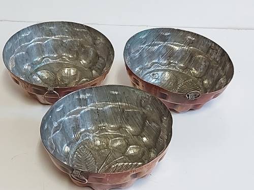 THREE VINTAGE COPPER JELLY MOULDS WITH A FRUIT MOTIF