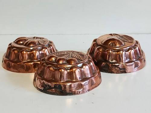 THREE VINTAGE COPPER JELLY MOULDS WITH A FRUIT MOTIF