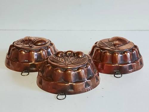 THREE VINTAGE COPPER JELLY MOULDS WITH A FRUIT MOTIF