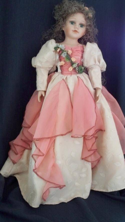 PORCELAIN DOLL WITH CREAM DRESS WITH SALMON PINK INLAYS.