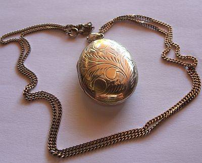 A STERLING SILVER NECKLACE WITH A LOVELY LARGE ENGRAVED OVAL LOCKET