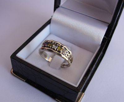 A SOLID STERLING SILVER RING SET WITH 4 FACETED GEMS - AMETHYST , PERIDOT ? ETC ETC