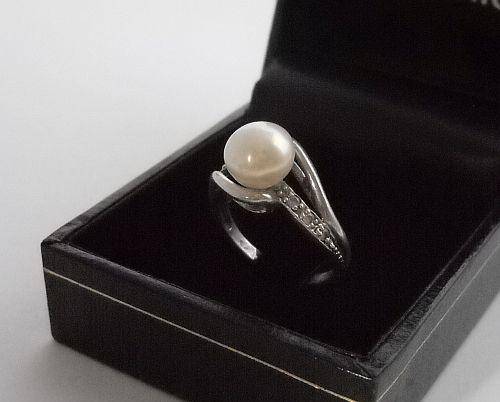 A SOLID STERLING SILVER RING SET WITH FACETED CZ STONES AND A MABE PEARL
