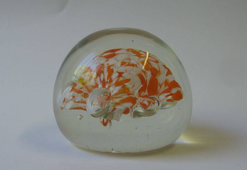 A COOL LOOKING VINTAGE SOLID GLASS PAPERWEIGHT WITH WHITE AND ORANGE SPECKLES DETAIL...NICE !!