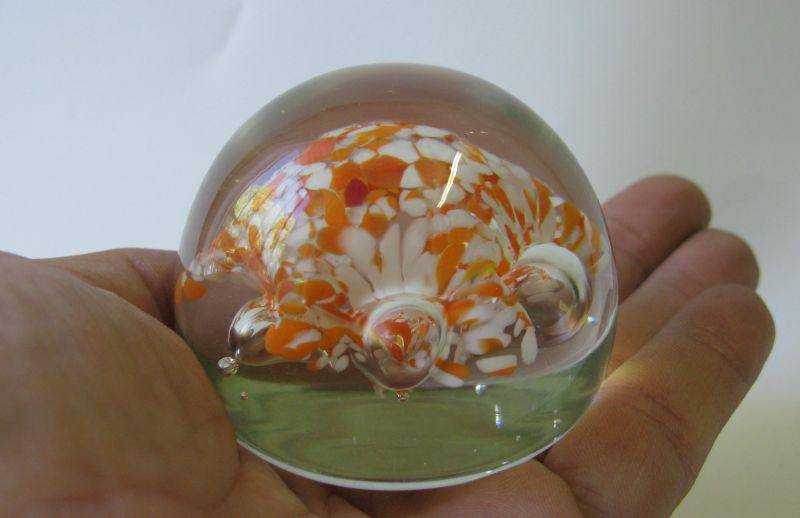 A COOL LOOKING VINTAGE SOLID GLASS PAPERWEIGHT WITH WHITE AND ORANGE SPECKLES DETAIL...NICE !!