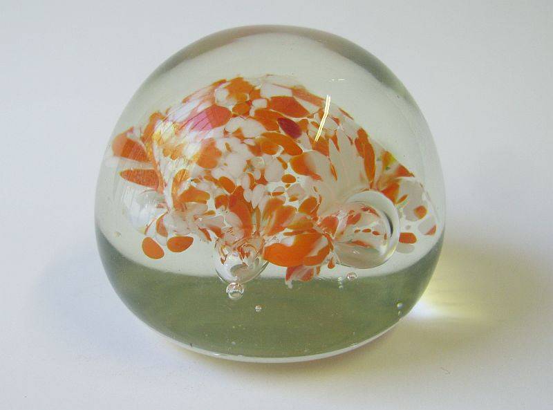 A COOL LOOKING VINTAGE SOLID GLASS PAPERWEIGHT WITH WHITE AND ORANGE SPECKLES DETAIL...NICE !!