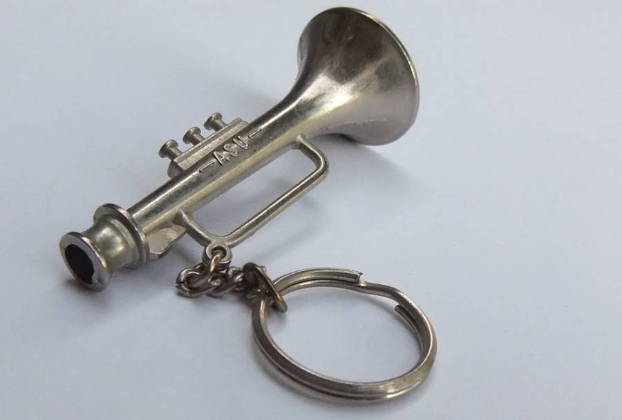 A VINTAGE SOLID METAL TRUMPET MOTIF KEYRING