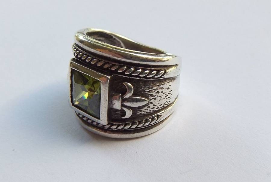 A GORGEOUS THICK HEAVY STERLING SILVER RING WITH FACETED GREEN STONE AND FLEUR DE LIS MOTIF - TESTED