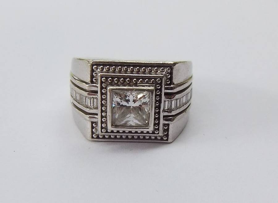A SUPERIOR QUALITY SOLID STERLING SILVER RING SET WITH FACETED BAGUETTE CUT STONES AND A SQUARE CZ