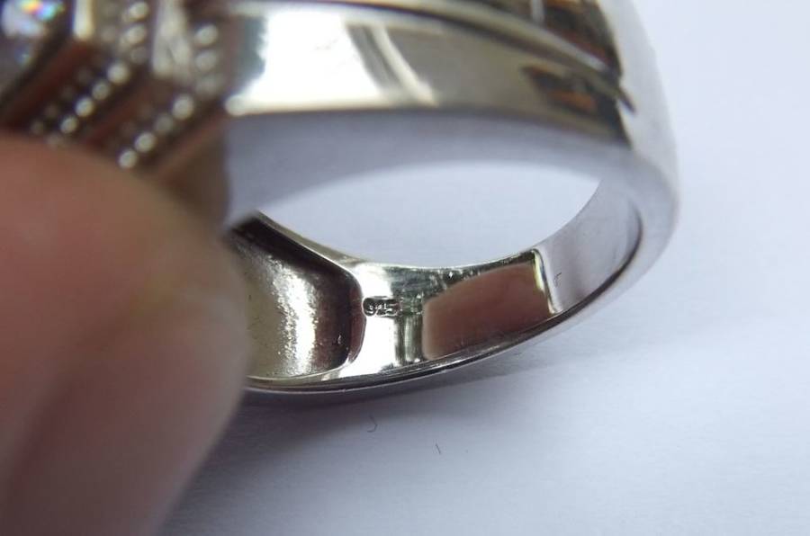 A SUPERIOR QUALITY SOLID STERLING SILVER RING SET WITH FACETED BAGUETTE CUT STONES AND A SQUARE CZ