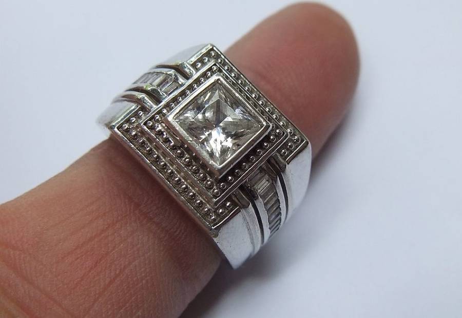 A SUPERIOR QUALITY SOLID STERLING SILVER RING SET WITH FACETED BAGUETTE CUT STONES AND A SQUARE CZ