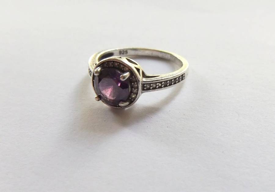 A CLASSY SOLID STERLING SILVER RING SET WITH A FACETED PURPLE STONE AND SMALL CLEAR STONES !! TESTED
