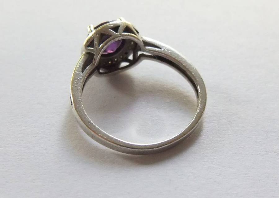 A CLASSY SOLID STERLING SILVER RING SET WITH A FACETED PURPLE STONE AND SMALL CLEAR STONES !! TESTED