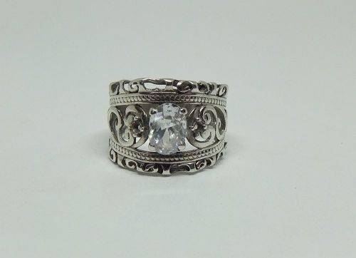 A CHARMING SOLID STERLING SILVER RING SET WITH A FACETED CLEAR STONE !! LOTS OF CURVEY DETAIL !!
