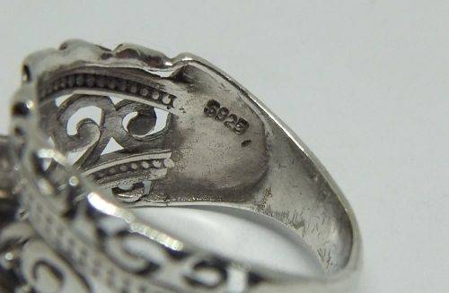 A CHARMING SOLID STERLING SILVER RING SET WITH A FACETED CLEAR STONE !! LOTS OF CURVEY DETAIL !!