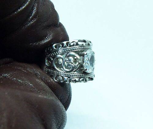 A CHARMING SOLID STERLING SILVER RING SET WITH A FACETED CLEAR STONE !! LOTS OF CURVEY DETAIL !!