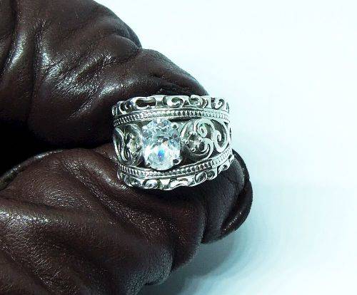 A CHARMING SOLID STERLING SILVER RING SET WITH A FACETED CLEAR STONE !! LOTS OF CURVEY DETAIL !!