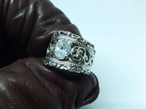 A CHARMING SOLID STERLING SILVER RING SET WITH A FACETED CLEAR STONE !! LOTS OF CURVEY DETAIL !!