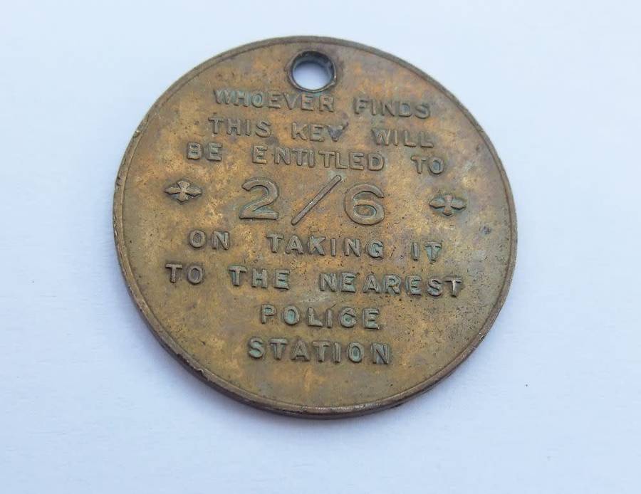 A vintage South African Post Office lost key token entitling the finder to 2 shillings and 6 pence