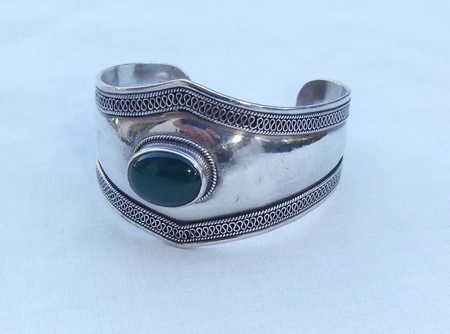 A solid sterling silver cuff bangle with a green cabochon inset - stamped & tested