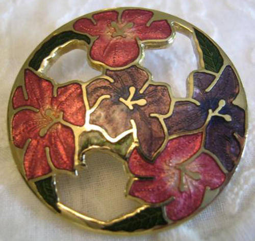 FLORAL, ENAMELED BROOCH WITH ROLL OVER CLASP, GILT SETTING IN GOOD CONDITION.