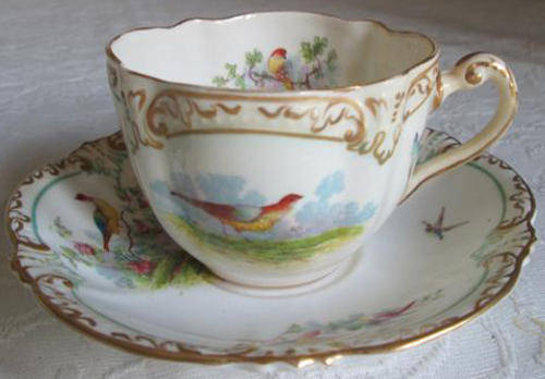 1891-1893  GEORGE JONES & SON,  CUP AND SAUCER, HAND TOUCHED OVER TRANSFER BIRD DESIGN WITH GILDING