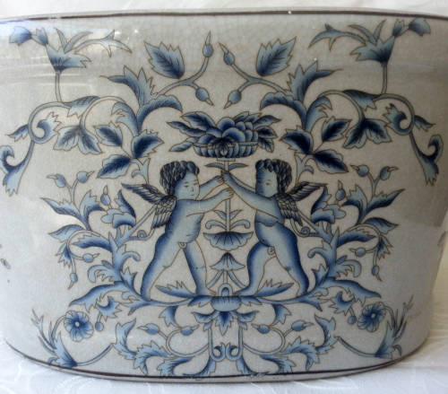 LARGE, HEAVY PORCELAIN, POT PLANT HOLDER WELL DECORATED WITH LEAVES, FLOWERS AND AN ANGEL OR TWO !!!