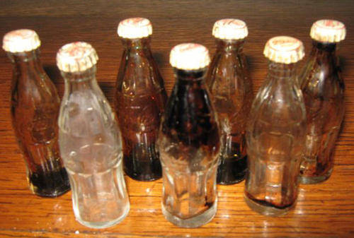 A COLLECTION OF 7  VINTAGE  MINATURE  GLASS COCA COLA BOTTLES 1950s