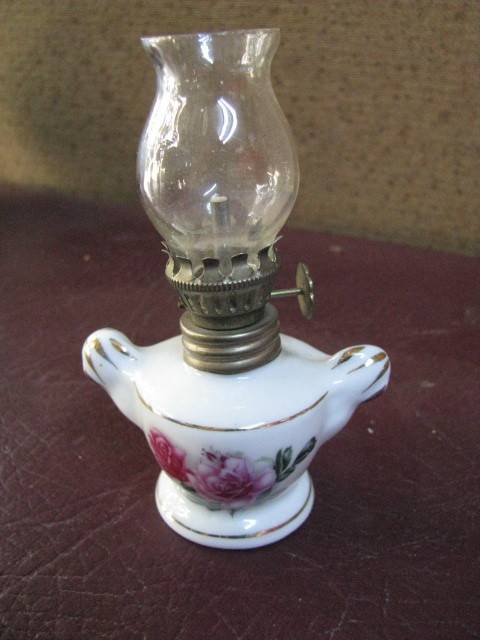 A VINTAGE SMALL PORCELAIN AND GLASS OIL LAMP...