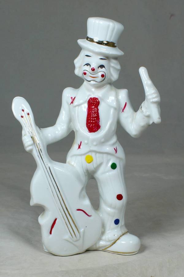 Clown in a polka dot suit playing a double base guitar