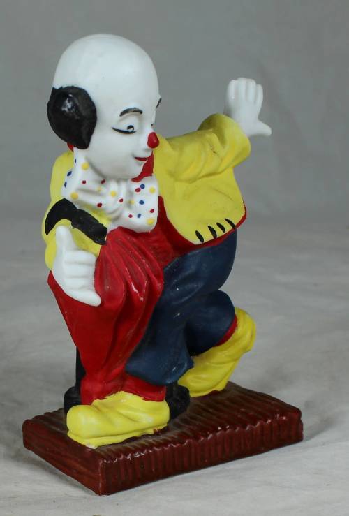 Ceramic clown on a stand striking a pose