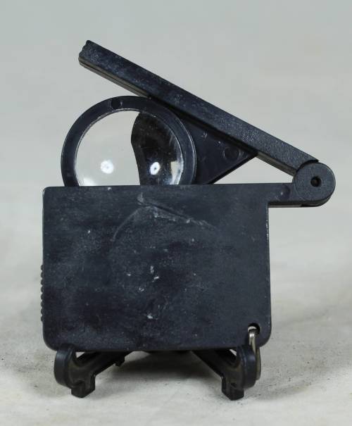 Miniature film clapper board with a magnifying glass