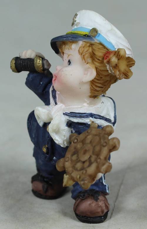 Kid sailor in blue holding a telescope and ships wheel