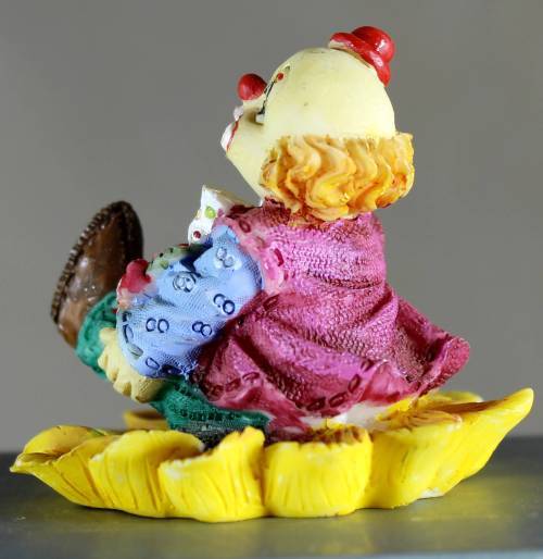 Small clown figurine seated on a sunflower