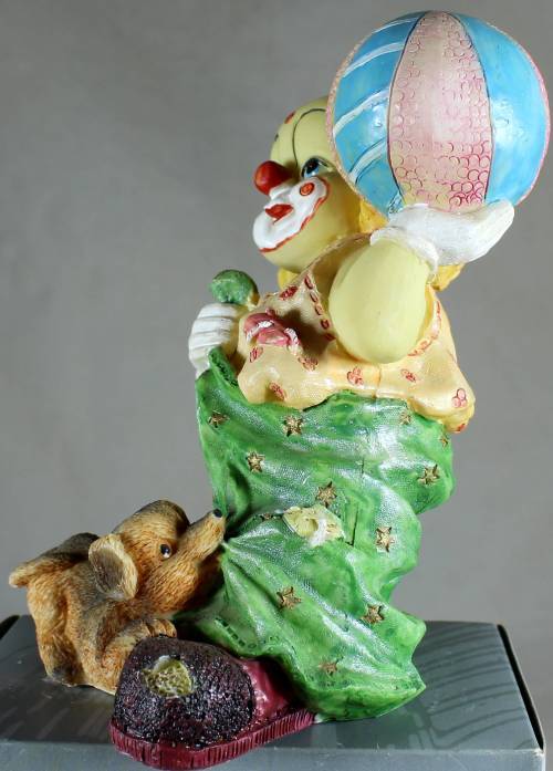 Clown figurine with large ball and playful puppy
