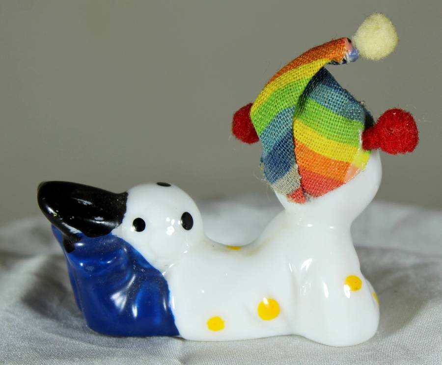 Clown laying on stomach with ball behind legs