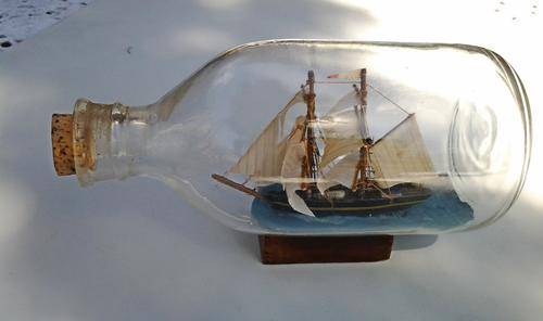 A lovely "HL / 65" Vintaged styled handcrafted ship in a glass bottle - see pics.