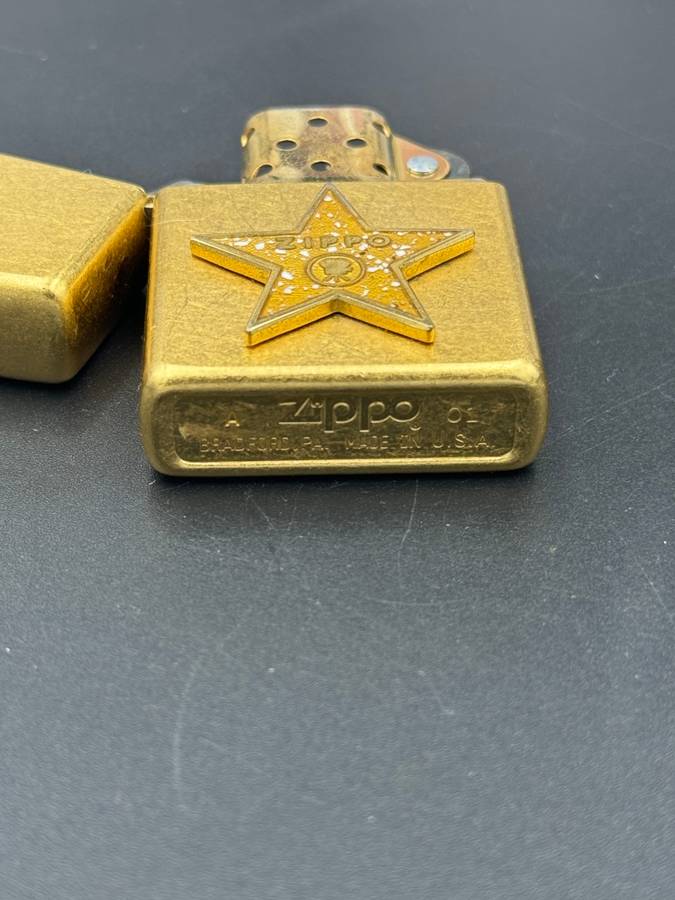 ZIPPO HOLLYWOOD'S LEADING LIGHT, A 2001 BRASS ZIPPO LIGHTER WITH APPLIED HOLLYWOOD STAR DESIGN