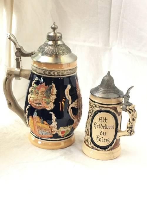 Set of 2 Graduating German Pottery Beer Steins Complete with pewter Lids.