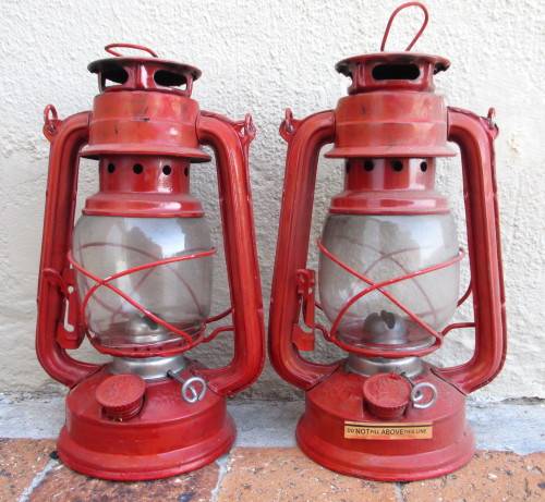 Two Red Parafin Lamps. 23cm high. As per photo