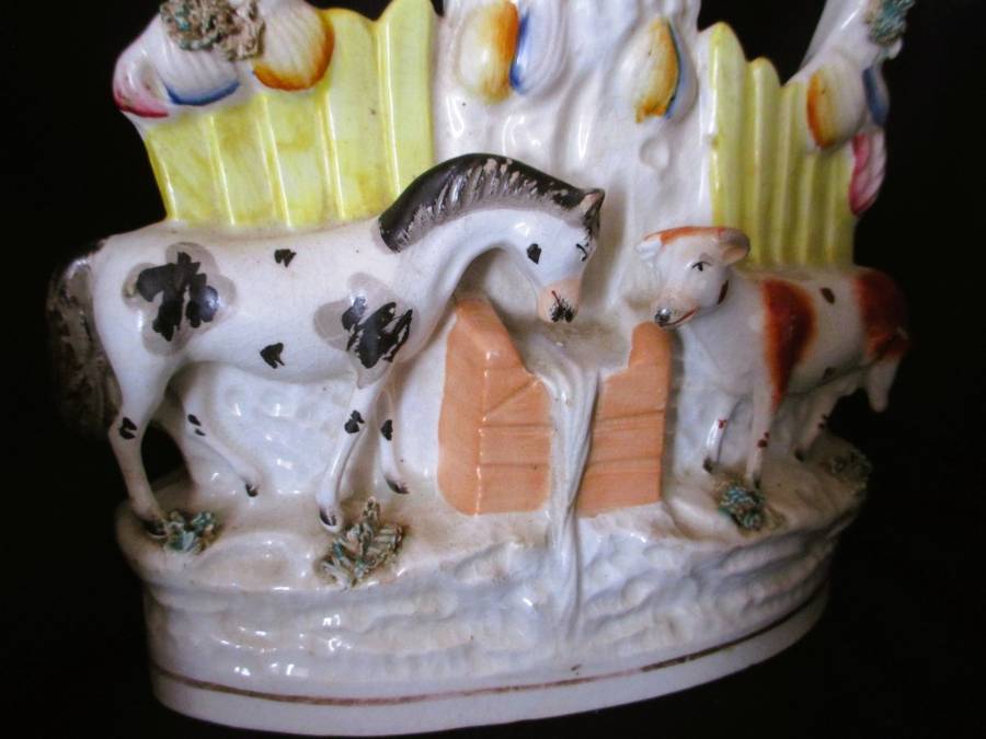 A Victorian Staffordshire spill, a cow and horse drinking from a trough beneath birds. Chip. 25x16cm